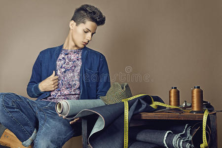 时尚年轻的帅哥年轻帅哥手握缝纫工具的时尚写真照片