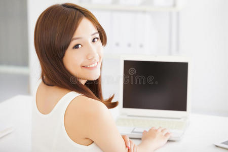 快乐的年轻亚洲女人在用笔记本电脑