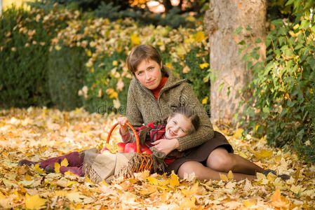 秋天公园里的女人和小女孩拿着苹果