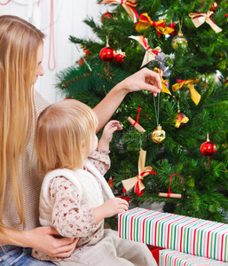 快乐的妈妈和女儿在装饰圣诞树