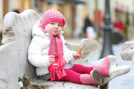 初学走路的女孩冬天在户外吃冰激凌