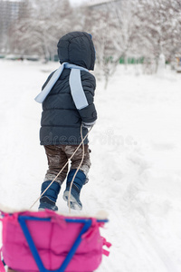 小男孩在雪林里雪橇