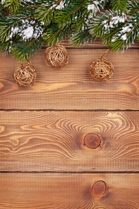 有雪的圣诞冷杉树和乡村木板上的小装饰品