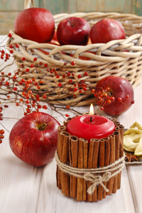 用肉桂棒和篮子里的苹果蜡烛装饰