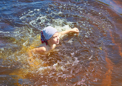 在河里或池塘里游泳的小女孩照片