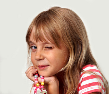 小女孩用珠子眨眨眼睛,在白色的背景构成构成的小女