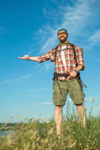 年轻的白种人男子与背包站在山上