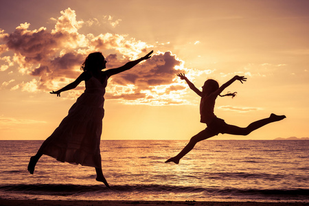 mor och dotter som spelar p stranden