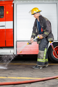 在培训期间在地板上喷洒水的消防队员