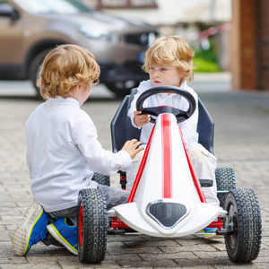 两个快乐的同级男孩在玩玩具车