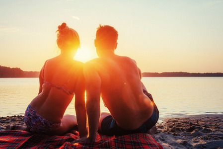 浪漫的情侣在七彩的晚霞，在海滩上背景