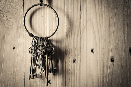 老式的钥匙挂在木墙背景