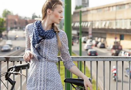 美丽的女人肖像在城市与她的自行车