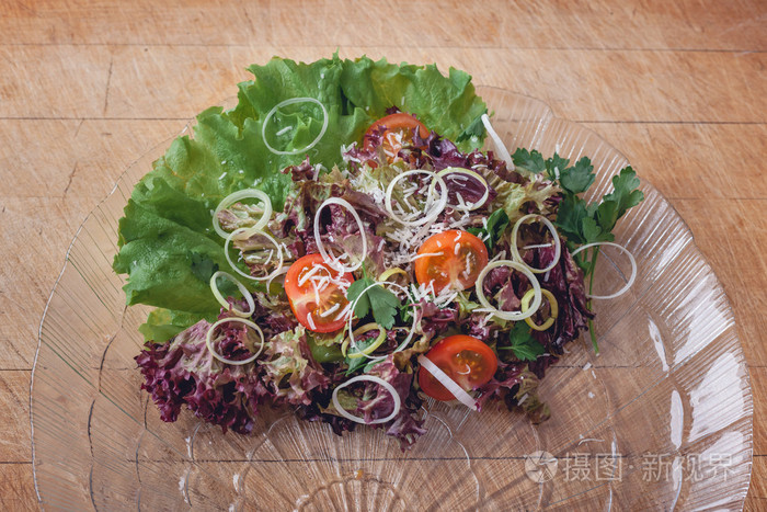 在带有s的木切割板上的玻璃菜沙拉