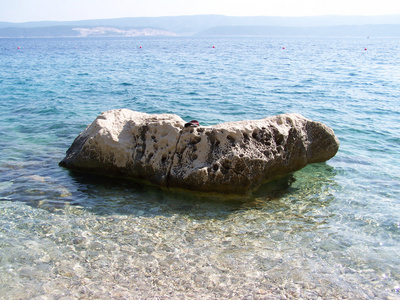 与巨大的岩石和小鹅卵石的克罗地亚海滩