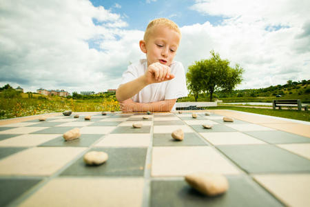 儿童在户外玩跳棋或跳棋棋盘游戏