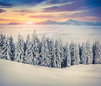 冬天美丽的日出雾蒙蒙的山。