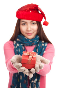 带圣诞帽和礼品盒的亚洲女孩专注于盒子