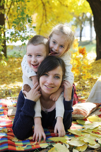 母亲和两个孩子躺在秋树下