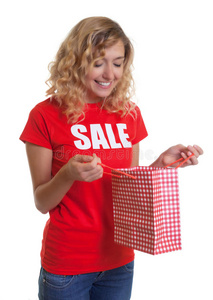 一个金发女人，穿着一件销售衬衫，手里拿着购物袋