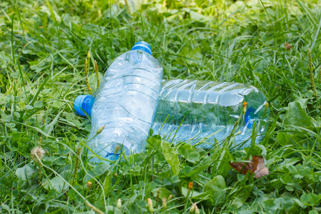 塑料瓶矿泉水在公园，草地上乱扔垃圾的环境