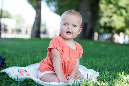 夏天的美丽的小女孩坐在草丛中的肖像