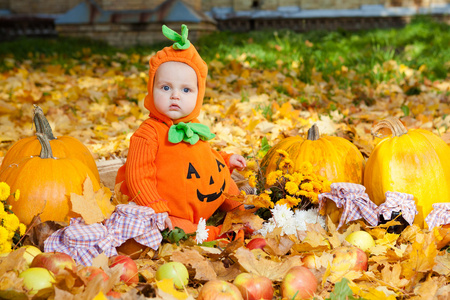 孩子在南瓜套装背景，秋天的落叶