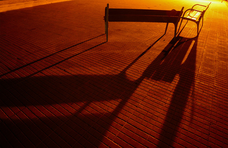 长椅和条铺砌的街道上的阴影