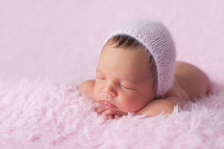 刚出生的婴儿女孩穿着一条粉色针织帽子