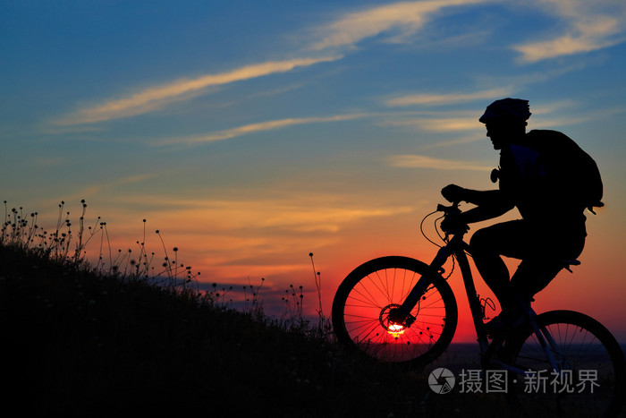 骑自行车的人和自行车对星空背景下的剪影