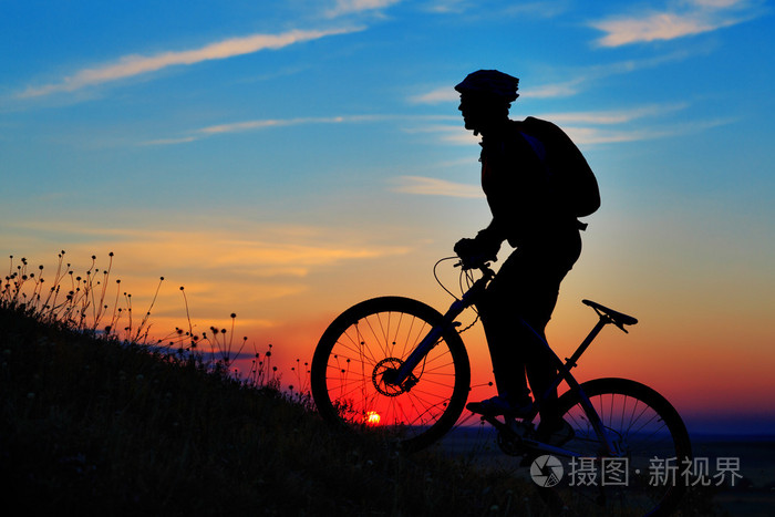 骑自行车的人和自行车对星空背景下的剪影