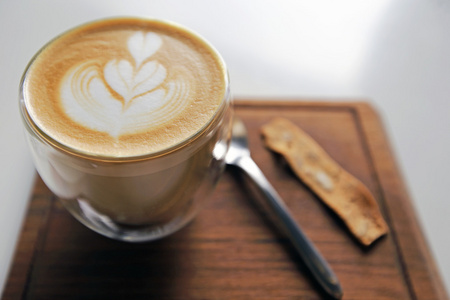 一杯咖啡，白色杯木制背景上的心模式