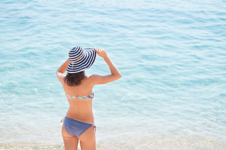 年轻女子在海滩举行的帽子