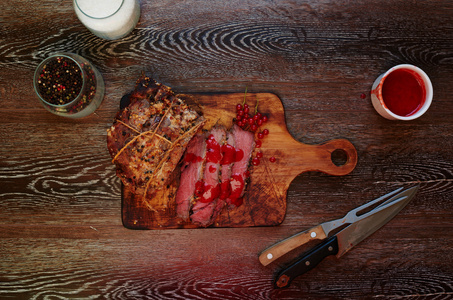 桌子上有一块木板, 厨师在上面把一块肉切成两半