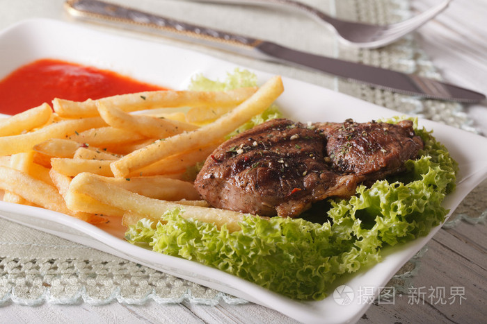 麻辣牛肉牛排配薯条和番茄酱特写.按