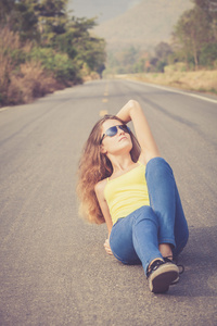太阳镜的新潮时髦女孩放松在路上