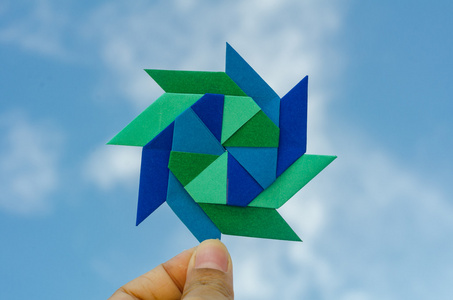 手拿着多彩的风标折纸折叠纸照片