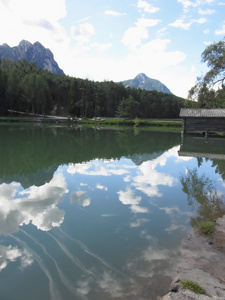 有云倒影的小山湖。fie allo sciliar, south tyrol, 意大利