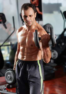 男人做二头肌训练器在健身房