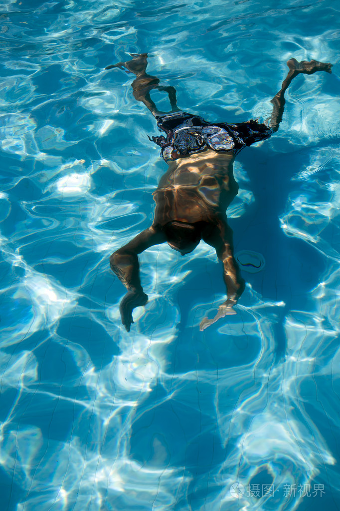 在游泳池中潜水水下的男人反射