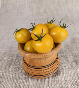 新鲜的黄色樱桃番茄在一个木制的质朴罐子