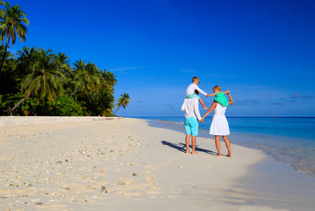 年轻的家庭，两个孩子在海滩散步