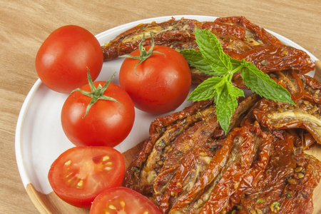 用橄榄油腌制的辣干的西红柿。可口的美味。在聚会的茶点。晒干的番茄，橄榄油，背景。健康的食物