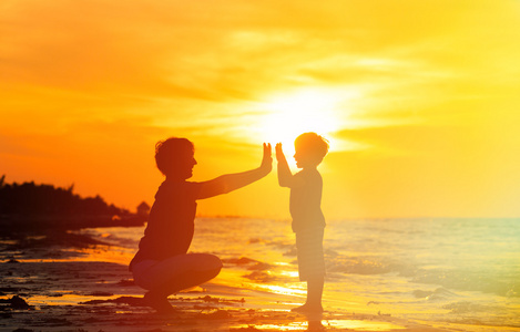 父亲和儿子玩海上日落