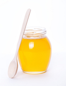 玻璃罐装满了白色背景上的蜂蜜。食品 医药