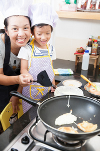 小的亚洲女孩制作煎饼