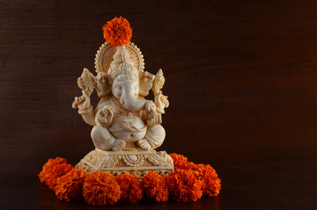印度教的神甘尼萨。甘尼萨偶像棕色背景与花