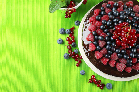 美味的巧克力蛋糕，与夏季莓上绿色的台布，特写