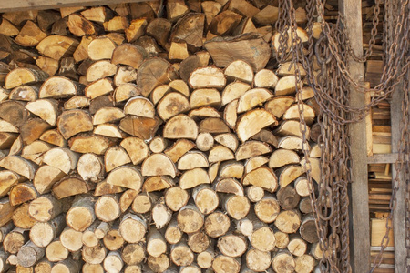 堆叠木材的背景。各种木原木堆叠在一起。堆叠的木头, 柴火, 背景。干切碎的柴原木准备过冬