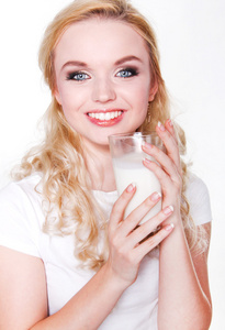 女人喝牛奶。快乐和微笑美丽的年轻女子试试